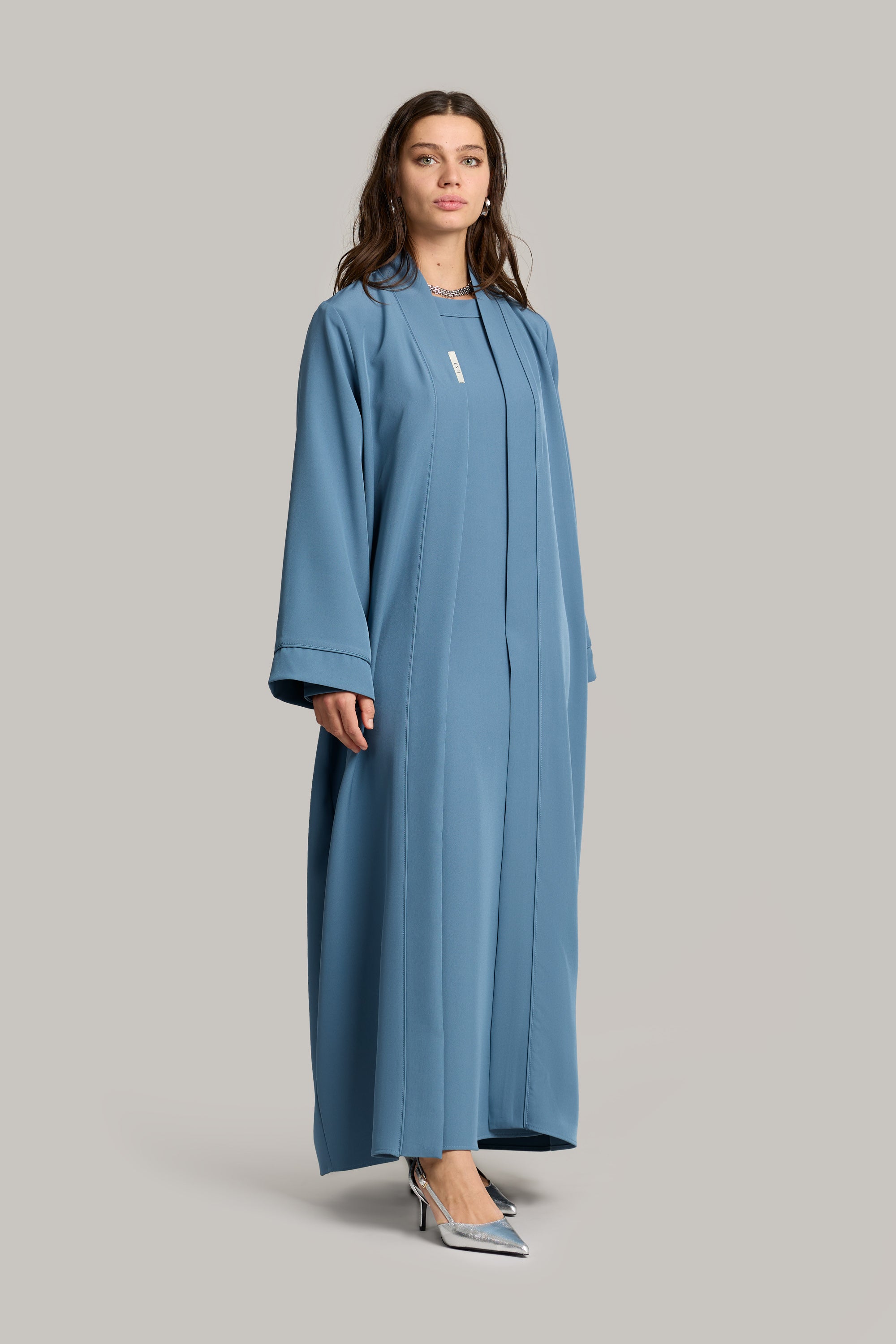 model draagt de essential abaya en kimono set in de kleur zacht blauw van het merk ENTI.